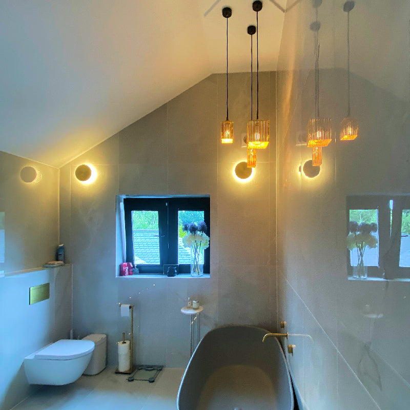 Gold leaf pendant lights hanging in modern white bathroom
