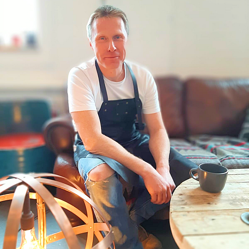 Gwyn Carless lighting designer in apron smiling 