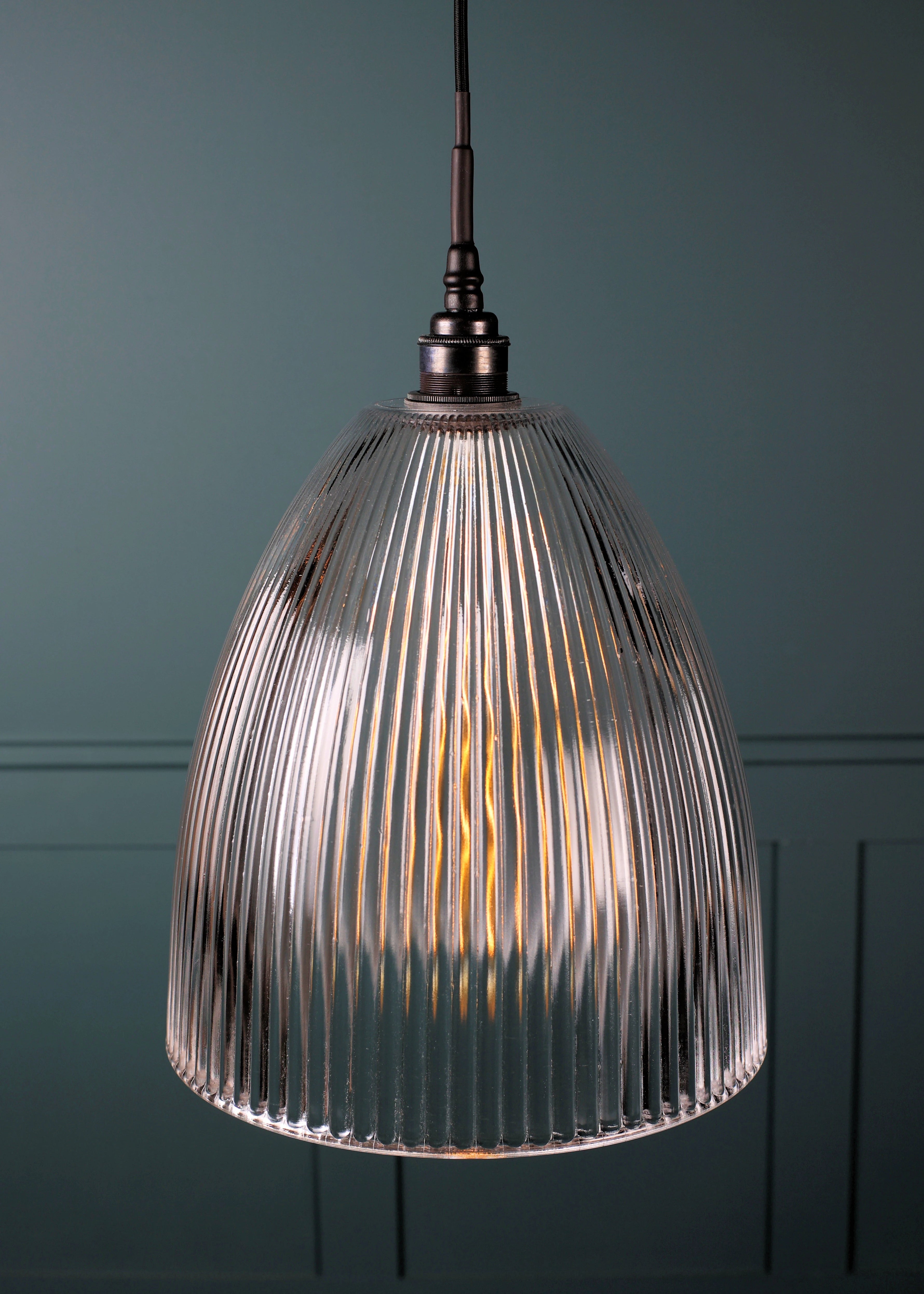 Large domed glass bathroom pendant light with bronze lamp holder on teal coloured background