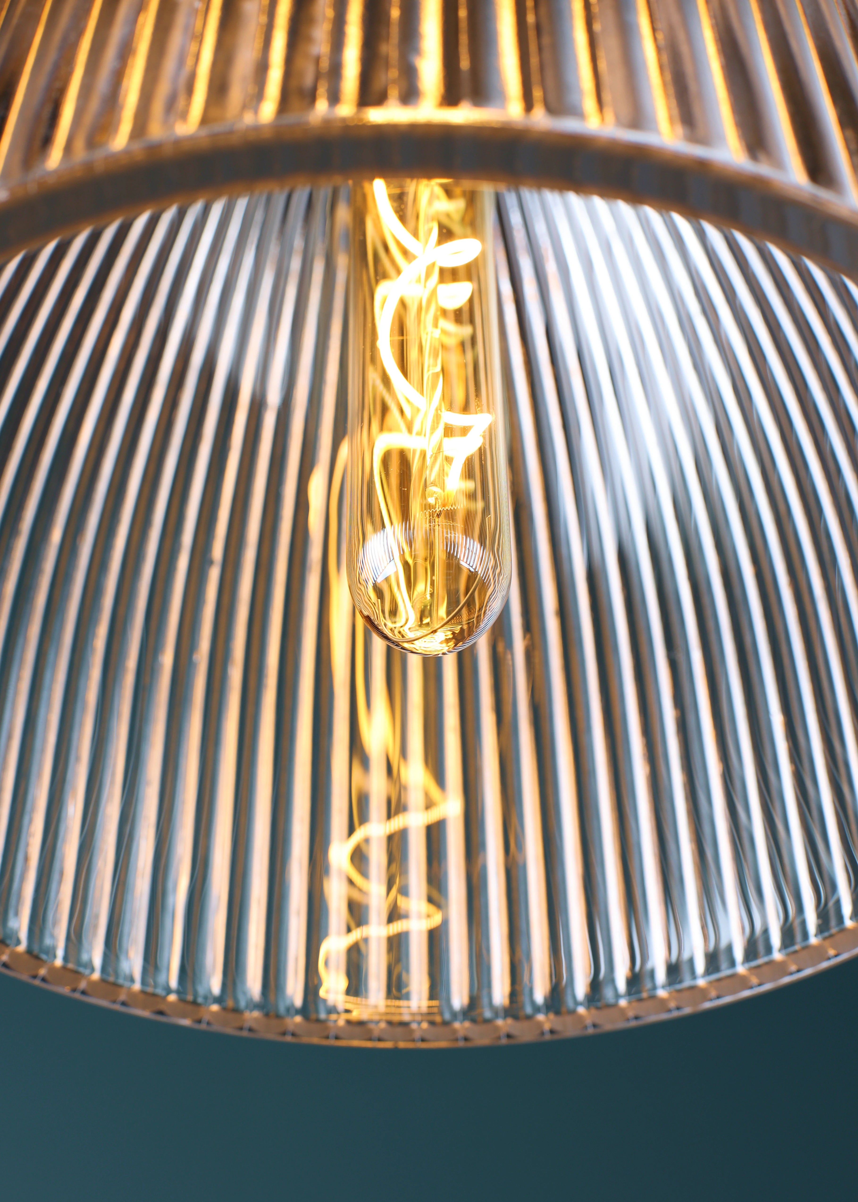 Close up image of large domed glass bathroom pendant light and light bulb