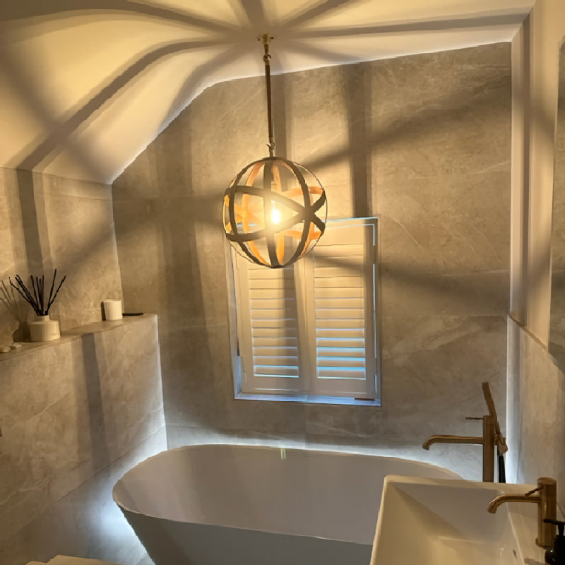Modern bathroom with a freestanding bathtub, sink, and IP44 Orbital decorative light fixture.