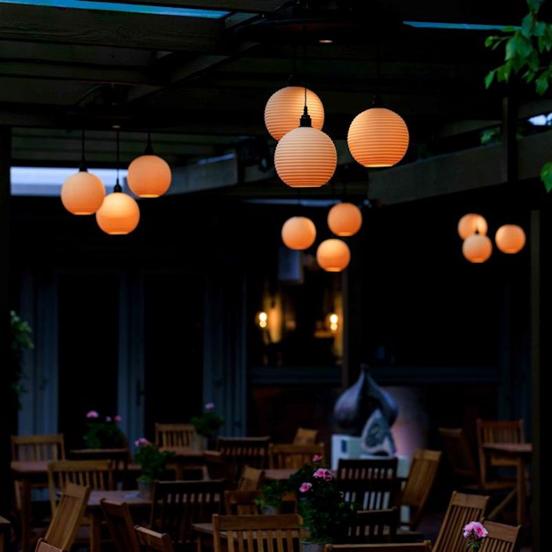 Round ceramic pendant lights hanging  in garden pergola at RHS Chelsea 