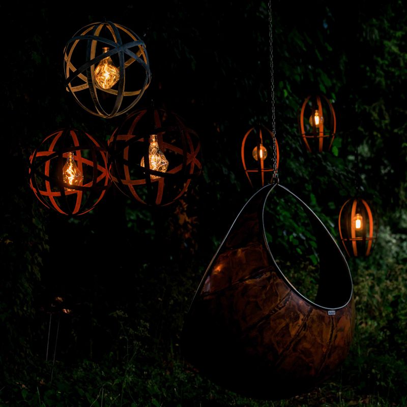 Industrial outdoor Orbital pendant lights suspended from tress at Jardin Blanc 