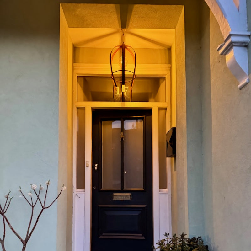 Decorative metal pendant light hanging in porchway of luxury London house