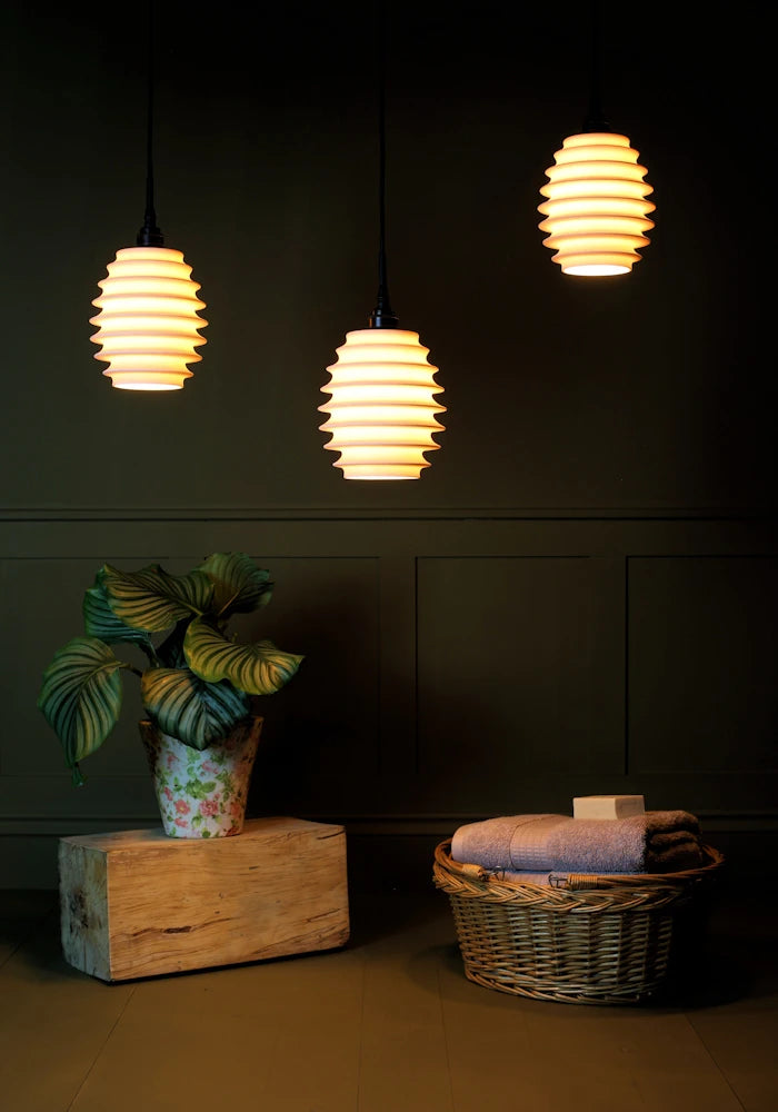 Concertina style porcelain cluster bathroom pendant light with plant and basket of bath towels 