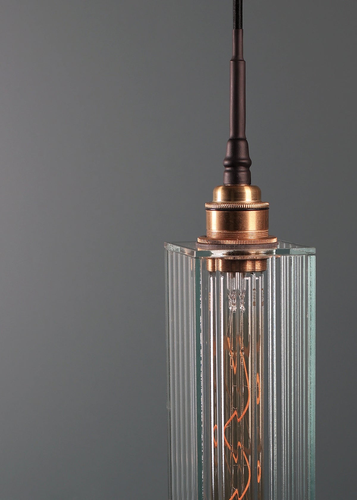 Long rectangular ribbed glass bathroom pendant light with brushed brass lamp holder.