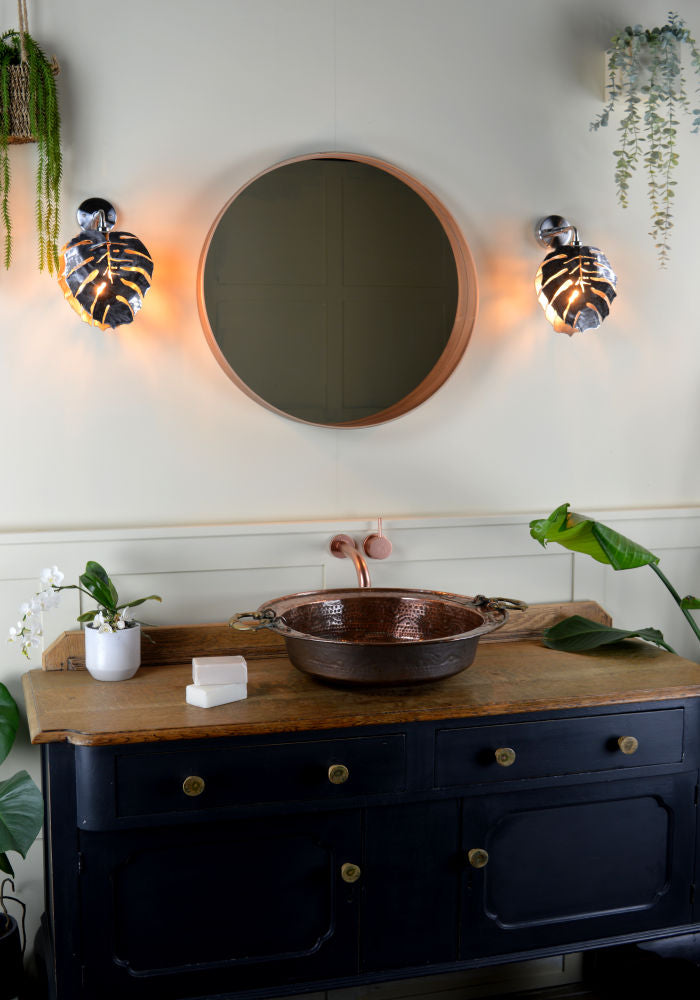 Industrial-style bathroom wall lights, copper sink, ornate dresser