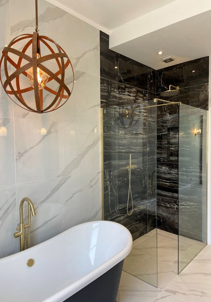 Orbital industrial style bathroom pendant light over bath casting shadows.